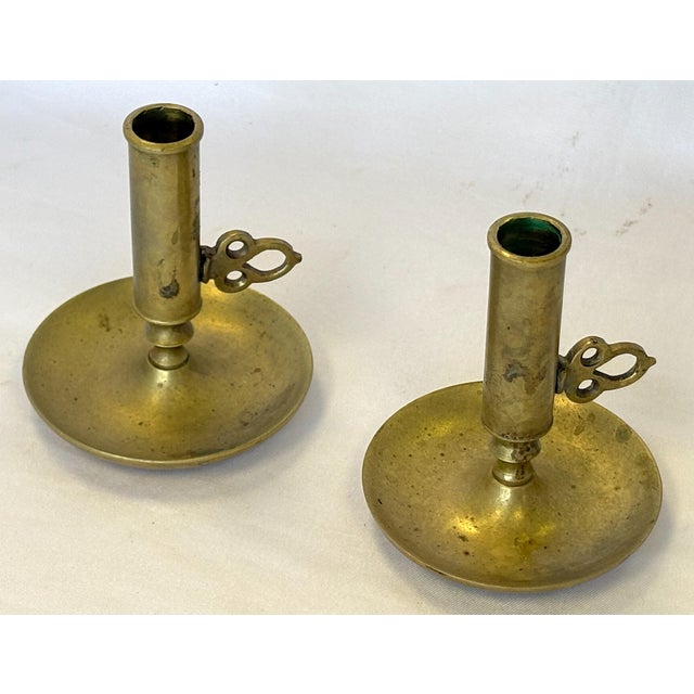 Historical pair of antique brass adjustable height candleholders. Each has a turnkey handle that moves the standard taper...