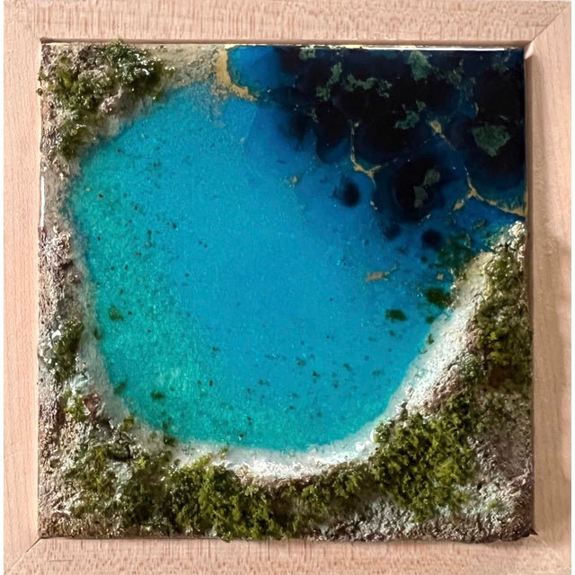 This artwork presents a serene aerial view of a vibrant ocean, with layers of tinted resin creating a depth that mimics...