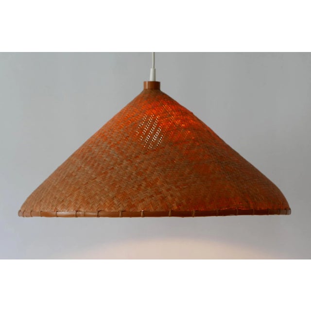Lovely Mid-Century Modern pendant lamp or hanging light. Manufactured probably in 1960s, Germany. Executed in wicker, it...