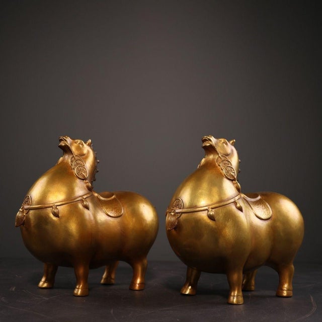 This is a charming and auspicious pair of vintage bronze sculptures depicting stylized "Money Horses." Modeled after Tang...