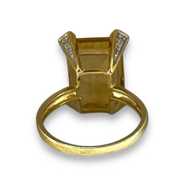 This exquisite piece radiates with the warm glow of a large, emerald-cut citrine, framed at the corners by delicate...