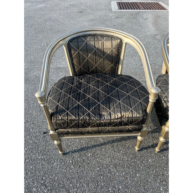 Rounded barrel chairs of carved wood with metallic painted finish. Newly upholstered seats with cushions in beige, tan,...