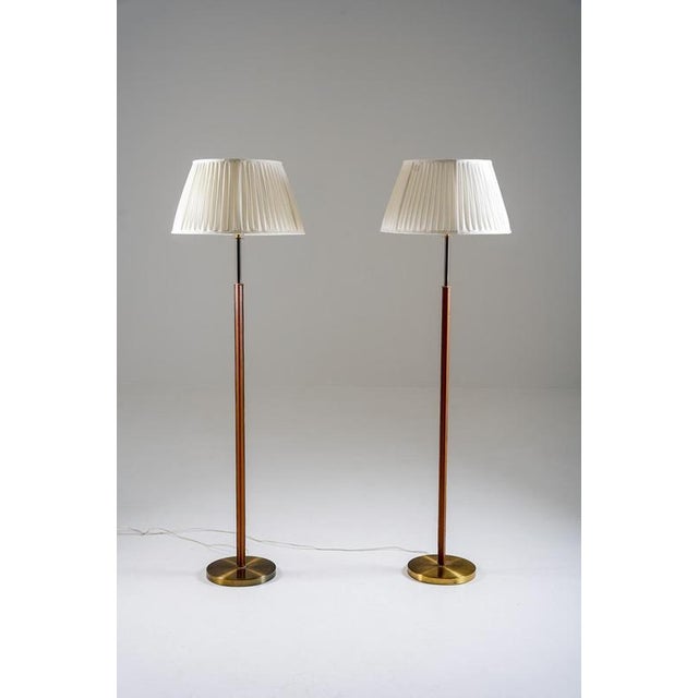 Refined pair of 1960s floor lamps by Philips. Each lamp features a slender stem wrapped in stitched leather, paired with...