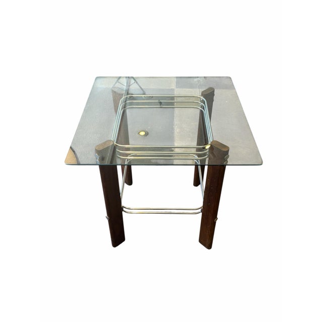 Elegant Mid-Century Modern table attributed to Heinz Meier, featuring a glass top supported by wood legs with chrome...