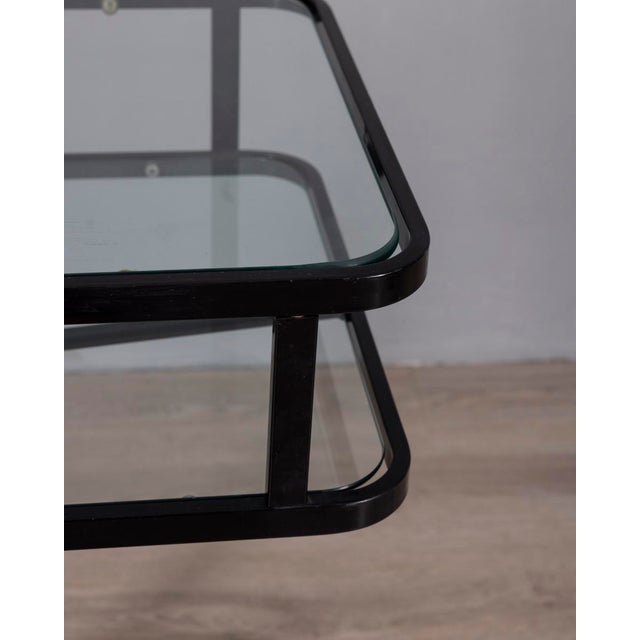 Black metal trolley table with double clear glass shelf, adjustable height, designed by Allegri Parma, 1970s. This piece...