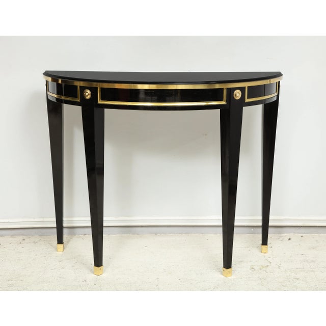 Bespoke Pair of Ebonized and Brass-Banded Demilune Consoles in the Neoclassic Manner We can make these consoles to your...