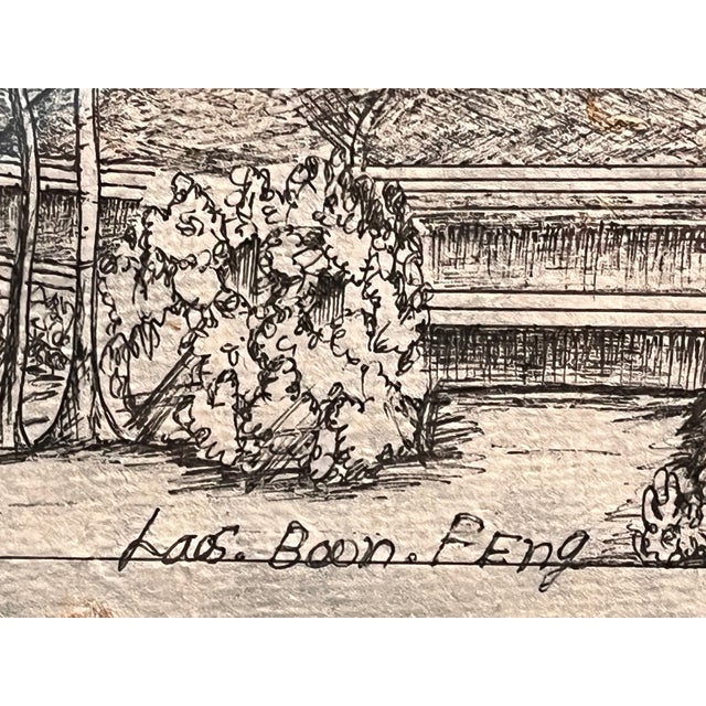 Laos Boon FEng framed artwork featuring a detailed black and white etching of a traditional village scene with temples,...