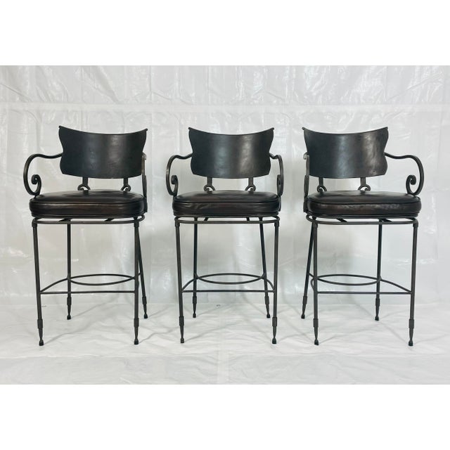 Set of three industrial-style counter stools designed and manufactured by Arhaus in the United States, featuring...