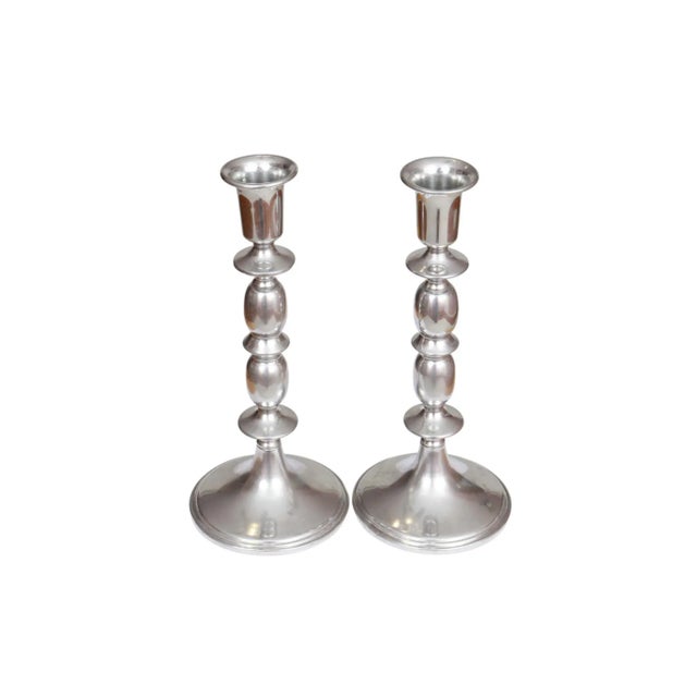 A pair of traditional pewter candlestick holders made by Empire Pewter. Silver pewter columns are elegantly curved with...