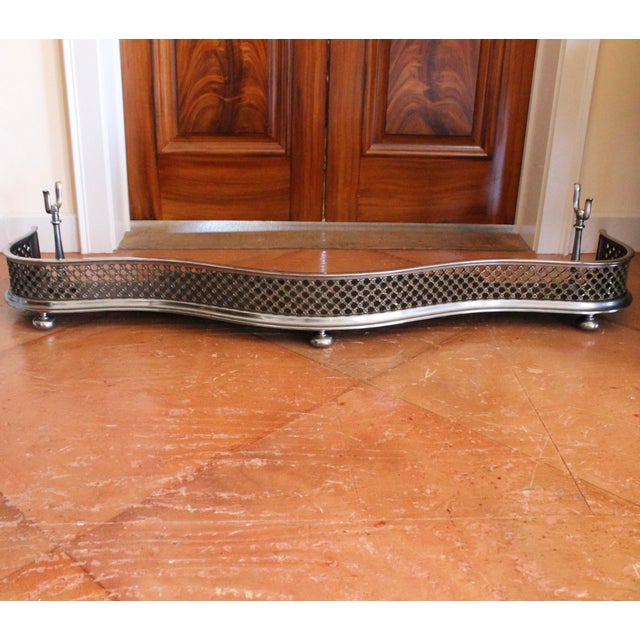 A fine serpentine shaped fender with a brass latticework grille set between mouldings of polished steel, and resting on...