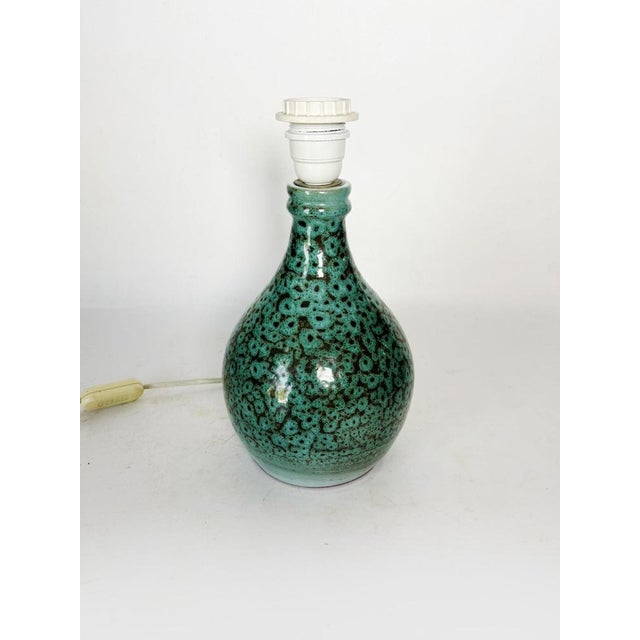 The lampshade is not included. A US adapter is provided. An elegant vintage French ceramic lamp from the 1960s,...