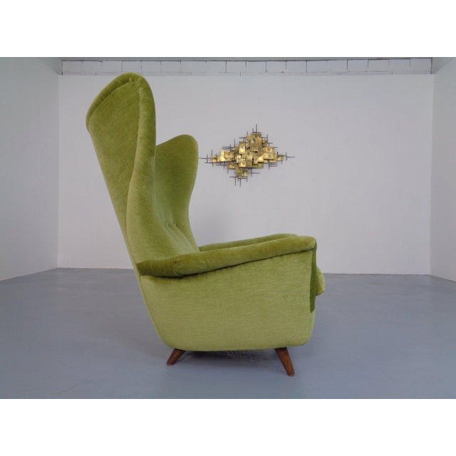 Wingback armchair upholstered in green mohair, in the style of Gio Ponti from the 1950s. Slightly flared teak legs. Loose...