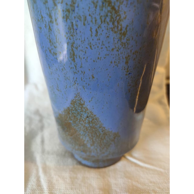 This object is an old cartridge case that has been transformed into a vase. This transformation of military objects into...