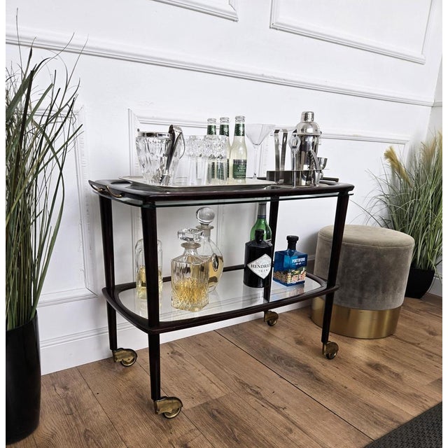 Unique and very elegant Italian Art Deco dry bar cabinet cart with two glass tiers and highlighted by the great wooden...