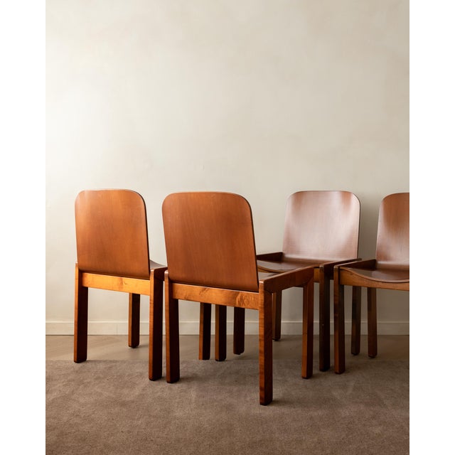 A vintage set of four italian dining chairs in warm-toned curved plywood and wood, attributed to molteni and produced in...