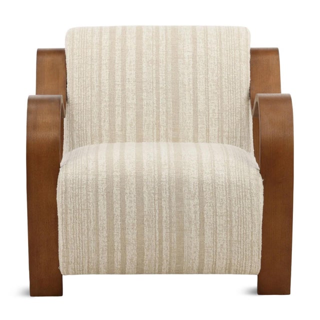 Chenille upholstered arm chair with striped textured pattern and cream coloring. Curved ribbon-like oak wood arms in warm...