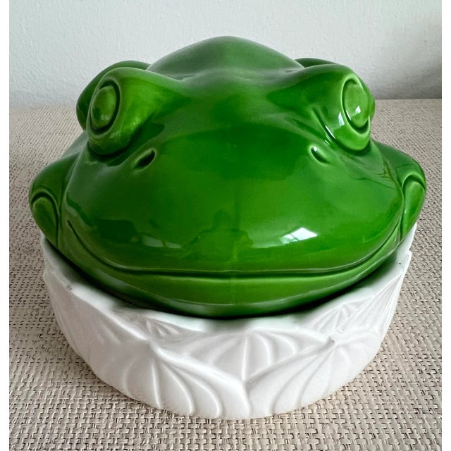 Very sweet porcelain vintage frog lidded box. Bright green frog lid atop shallow white lily pad container. Great on a...