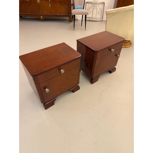 Beautiful pair of French Art Deco nightstands. Each with a top draw and a cabinet door below having silver hardware.