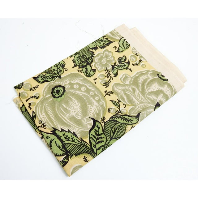 Mid 20th century cotton block printed fabric in subdued yellow and green shades. Pattern is floral with fruit and foliage.