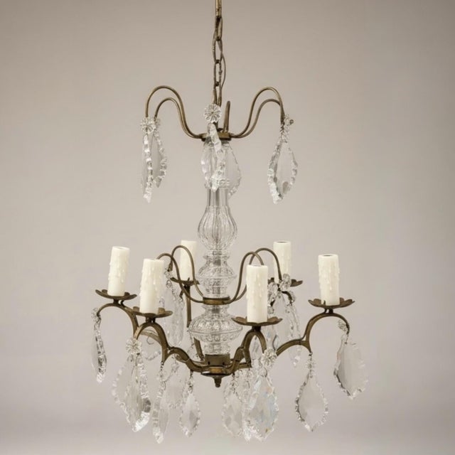 This is a petite French Louis XV style crystal and bronze six arm chandelier. It has been re-wired and newly cleaned. The...