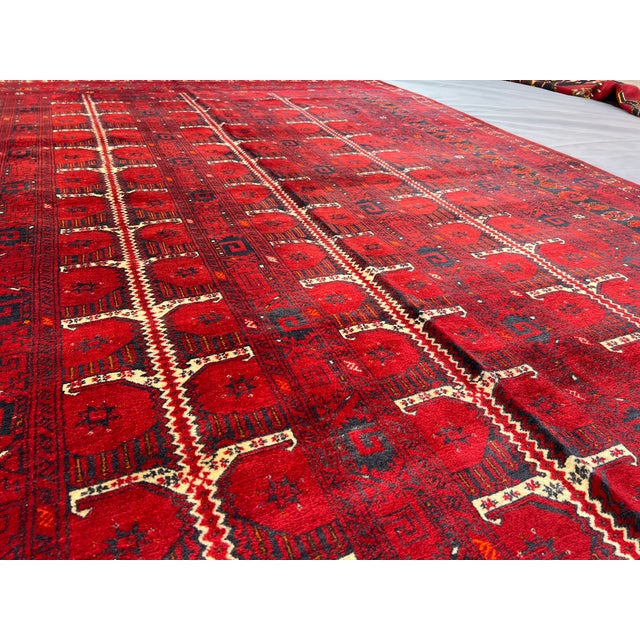 This exquisite vintage Turkmen Bukhara rug, hand-knotted in the 1950s in Kunduz City, Afghanistan, showcases the rich...