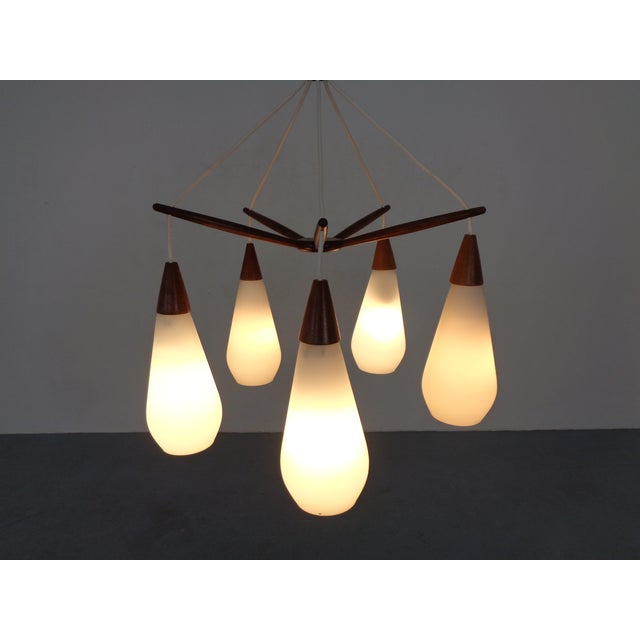Danish ceiling lamp with 5 light sources. Teak frame. The lamp is height-adjustable. Three replacement glass shades are...