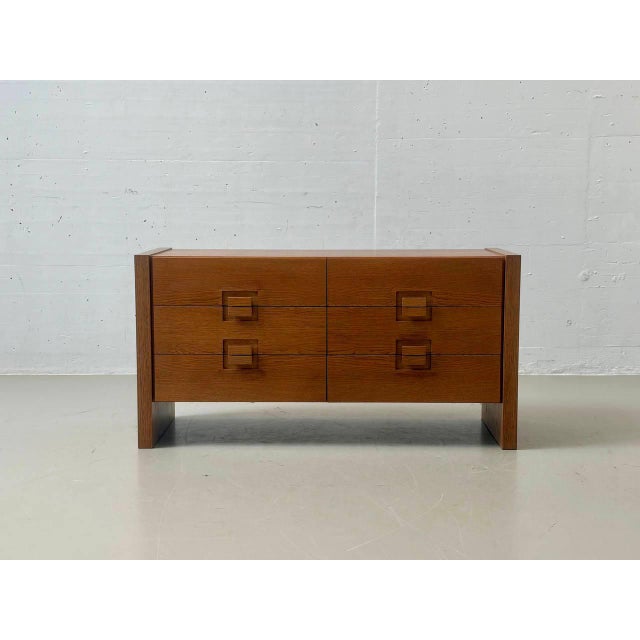 A striking mid-century sideboard crafted from oak, featuring clean, geometric lines. The straightforward construction,...