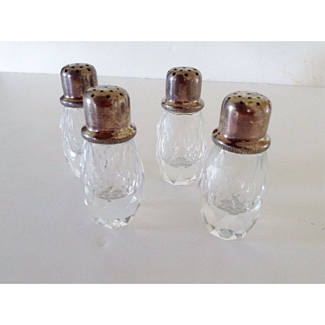 Two pairs of silver plated and cut glass salt and pepper shakers. Nicely weighted glass with silver plate tops that screw...