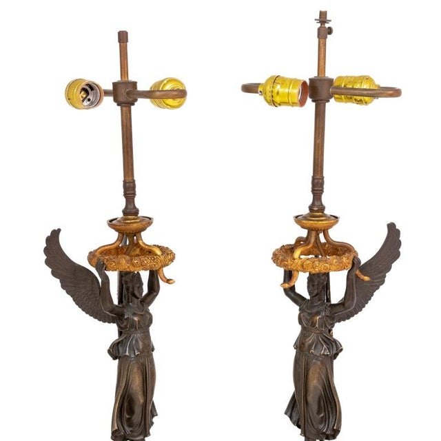 Pair of French Empire "Winged Victory" Patinated and Gilt Bronze Figural Lamps, circa 1830 and later mounted, each with a...