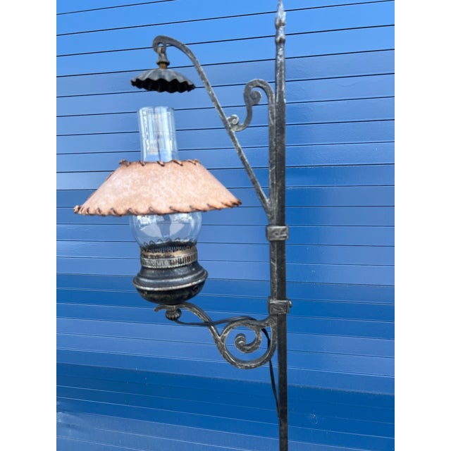 Handcrafted Monterey-style floor lamp featuring a wrought iron stand with scrollwork and a lantern-inspired light. The...