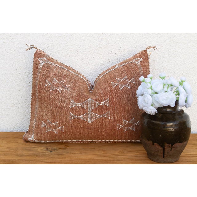 A stacked bowtie-diamond medallion runs the center of this handcrafted Moroccan cactus silk lumbar pillow, framed by two...