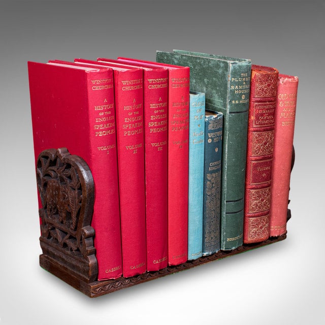 This is a vintage elephant motif book slide. An Anglo-Indian, teak home library stand, dating to the Art Deco period,...