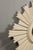 Modern painted wood sunburst mirror with light painted finish, small convex mirror and rays of alternating heights. This...