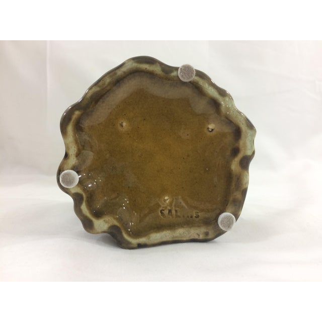 This is a very sweet tobacco jar with purple flowers and a snail affixed on the lid. It is unusually shaped and has a...