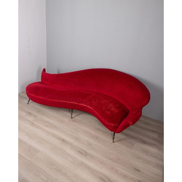 Large curved sofa with red velvet upholstery, black metal legs with golden brass tips, Italian design, 1950s.
