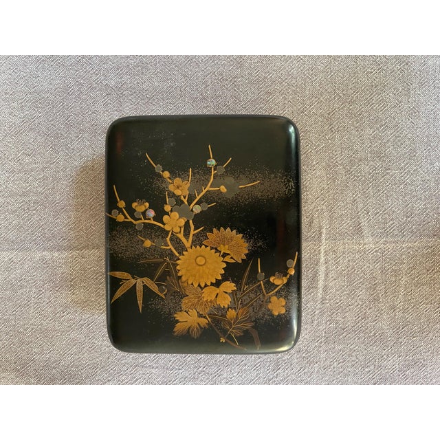 Black lacquered maki-e (Urushi), decorated with golden chrysanthemums. The technique used is called "Shishia Togidashi...
