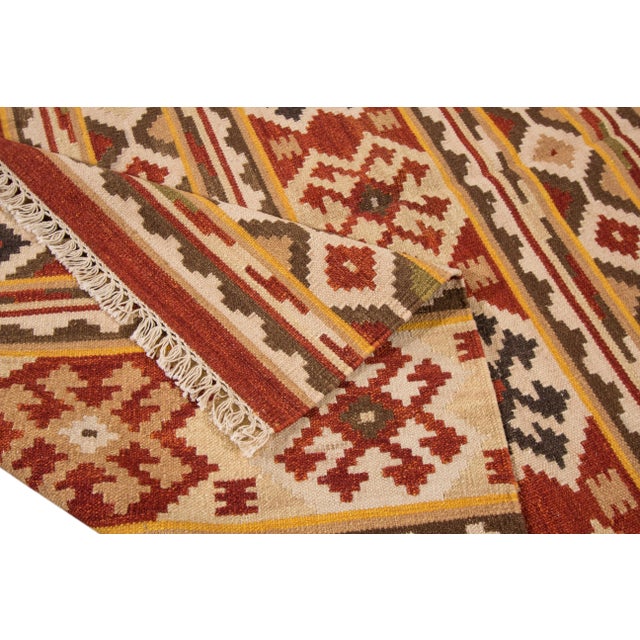 Beautiful Modern Kilim Hand-knotted wool rug with a tan field and Multi-color accents in-all-over geometric design. This...