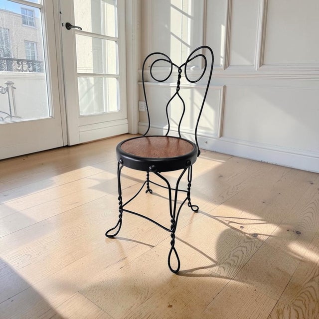An antique American child’s chair dating to circa 1900–1915, constructed from delicately formed iron and steel wire with...