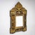 Baroque-style wall mirror with projecting corners and a central mascaron crest in a pyramidal composition. The frame is...