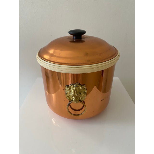 Vintage copper ice bucket with brass lion head ring handles and off white removable plastic liner. Stamped on bottom...