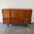 A large vintage Danish teak highboard dating to the 1960s, designed with generous storage across two levels and a warm,...