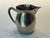 This exceptional Mid-Century Modern sculptural pitcher exemplifies the restrained elegance of post-war European metalwork....