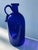 Wonderful blue bottle with profiled and polished rim. the peculiarity of the bottle is the wide handle and the serpentine...