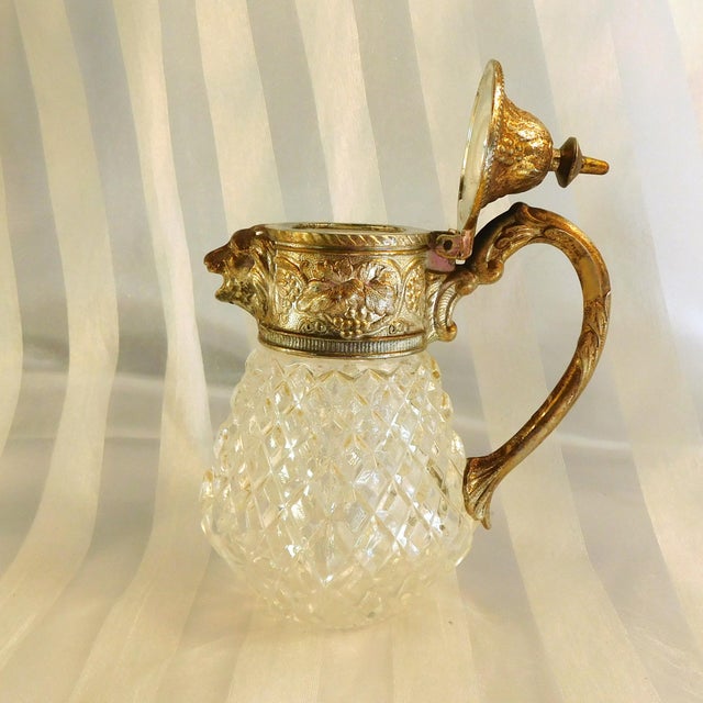 This is a cut crystal syrup pitcher with a silver metal top that does not come off. The top has a lid that opens and a...