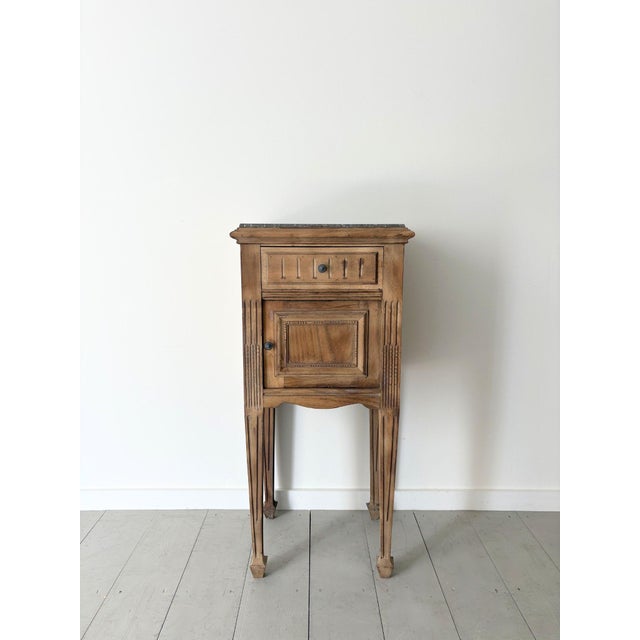An early 20th Century continental side table with a marble top and elegant tapered legs upon arrow feet. This refined...