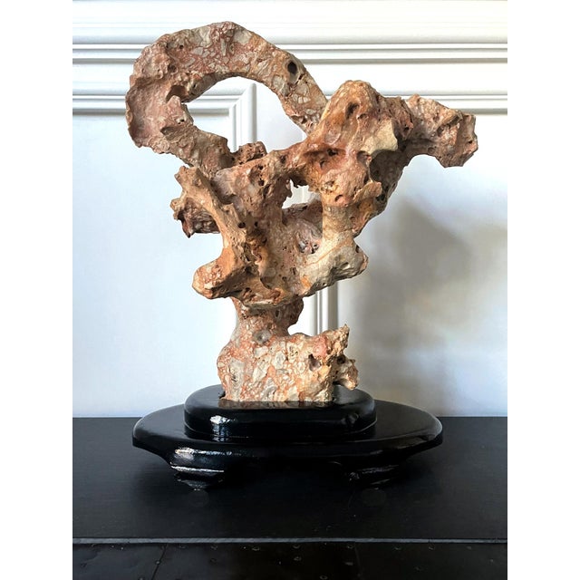 A Chinese scholar stone in an upright mushroom form displayed on a custom wood stand. Wonderful and well-balanced, the...