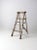 This is an antique wooden ladder. The four rung wood ladder has beautiful lines with open slat sides and lovely aged cream...