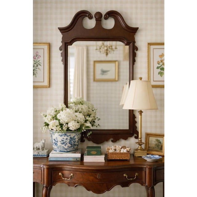A striking Chippendale‑style mahogany wall mirror featuring a broken pediment crest, central shell motif, and pierced...