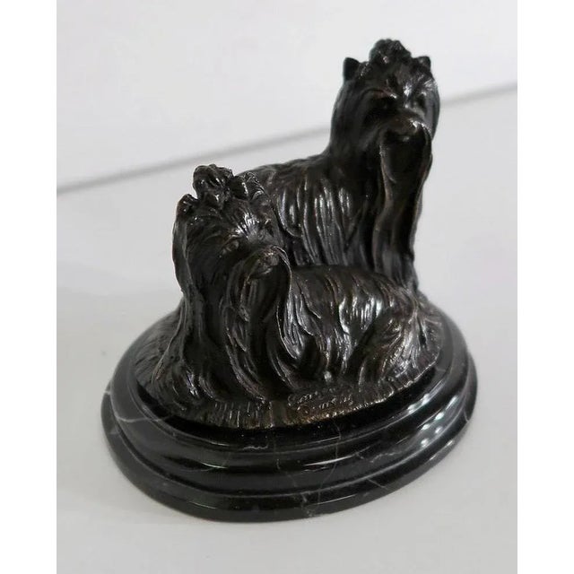 Small group in hard metal, representing a couple of Yorkshires, small dog taking its name from the English county but...