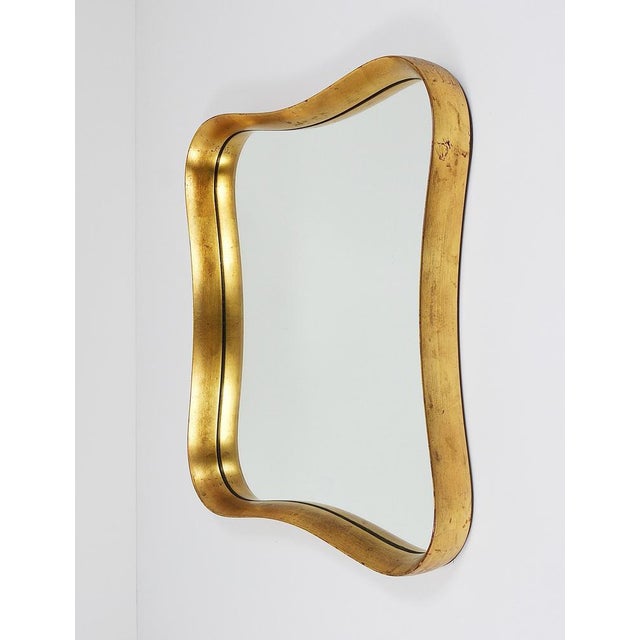 A wonderful Austrian modernist wall mirror with a lovely curved gold-plated lime wood frame from the 1940s. Manufactured...